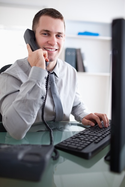 Glimlachende zakenman die een dialoog op de telefoon heeft