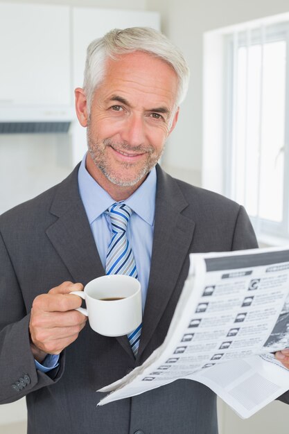 Glimlachende zakenman die koffie in de ochtend hebben vóór het werk