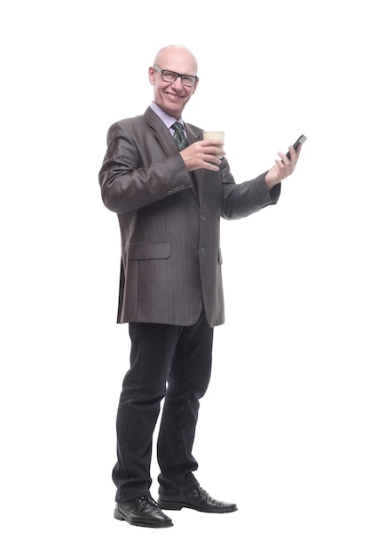 Glimlachende zakenman met een smartphone en een afhaalkoffie. geïsoleerd op een witte achtergrond.