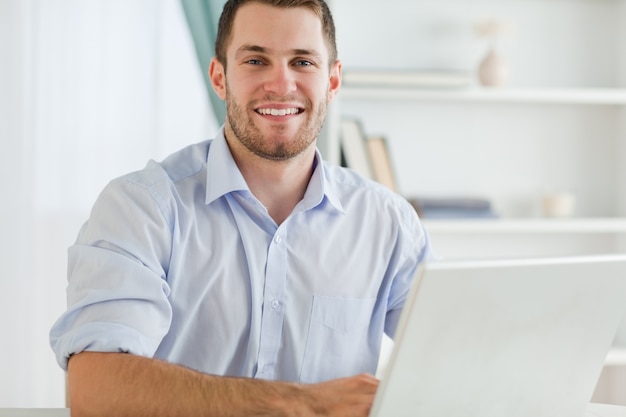 Glimlachende zakenman met opgerolde mouwen in zijn homebusiness