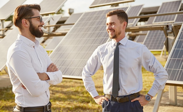Glimlachende zakenpartners bespreken werk in zonne-energiecentrale
