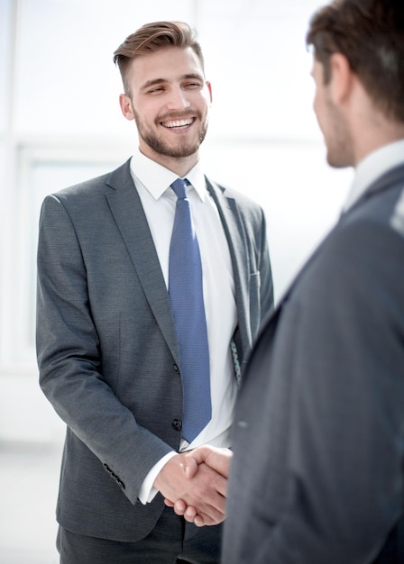 Glimlachende zakenpartners die handen schuddenconcept van samenwerking