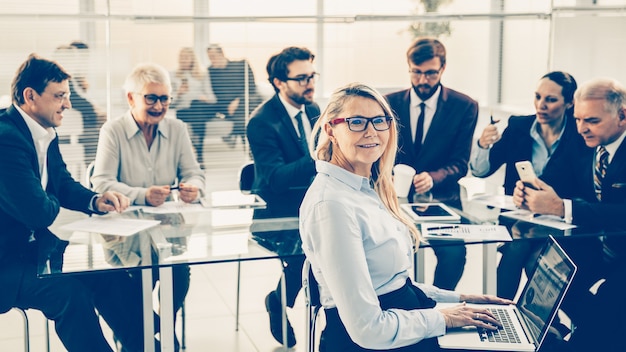 Glimlachende zakenvrouw die een werkvergadering begint met het zakelijke team. bedrijfsconcept.