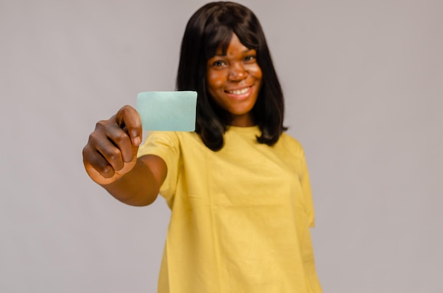 Glimlachende zakenvrouw houdt witte creditcard Geïsoleerd portret