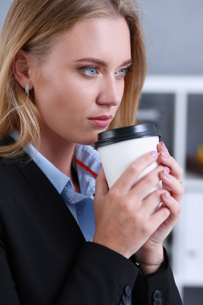 Glimlachende zakenvrouw koffie drinken