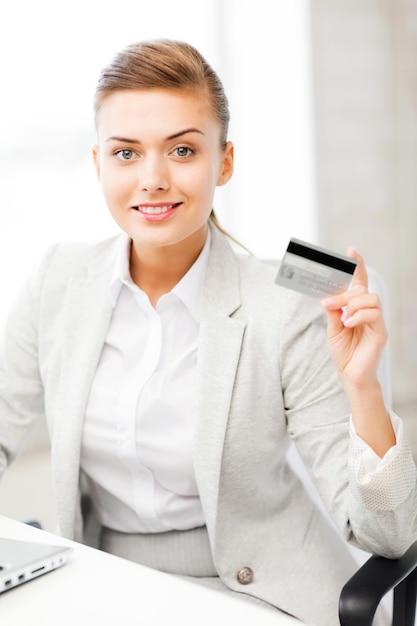 Glimlachende zakenvrouw met laptop met creditcard