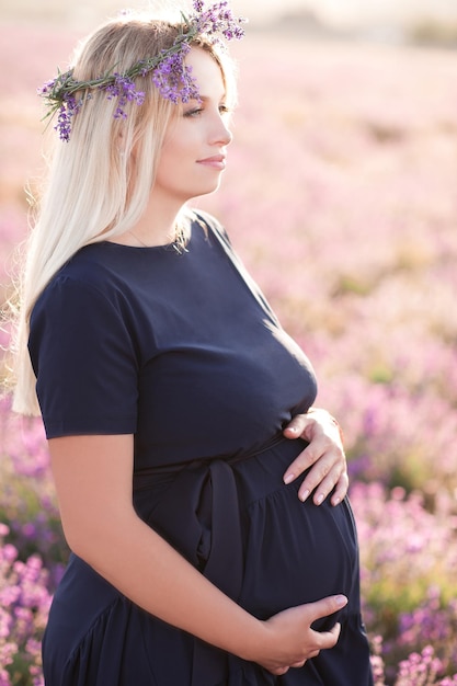 Foto glimlachende zwangere vrouw die op het veld staat