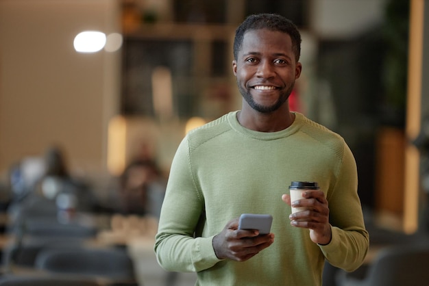 Glimlachende zwarte man met een smartphone.