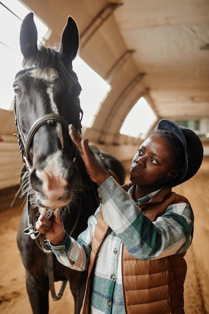 Glimlachende zwarte vrouw die van paardensport geniet