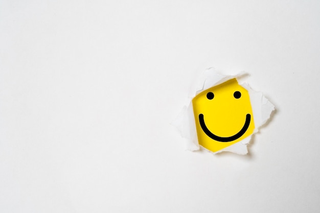 Foto glimlachgezicht binnen gele achtergrond en wit geperforeerd papier met kopieerruimte voor positieve mindset en klant uitstekend evaluatieconcept klantervaring en kwaliteitsfeedbackconcept
