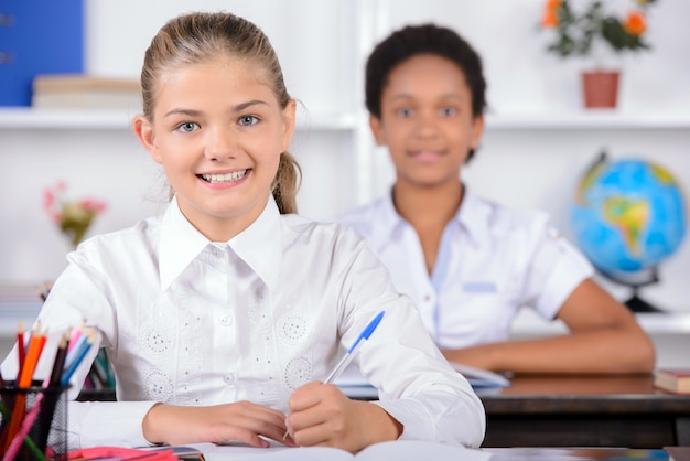 Glimlachleerlingen glimlachen op school in de klas.