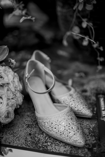 Foto glinsterende bruidsschoen met bloemenboeket in zwart-wit