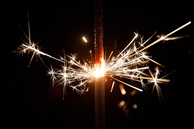 Foto sparkler ardente scintillante su sfondo nero.