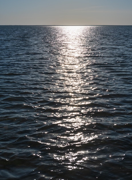 夕陽のきらめきが海面に反射 波に乗って海面にきらめく陽光 きらめく水の背景