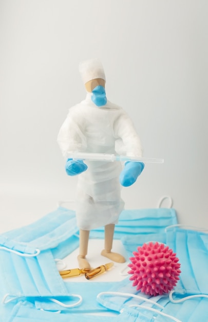 The global epidemic of coronavirus.man in protective medical uniform and with syringe in his hands.Nearby lies a cell of the COVID-19 virus. The concept of controlling outbreaks of the SARS epidemic.