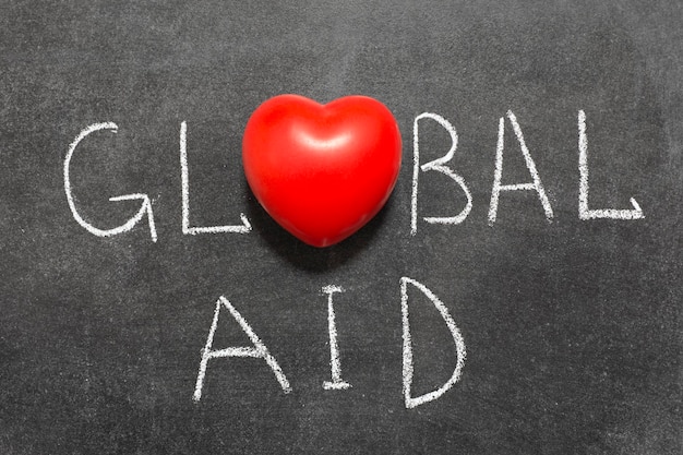 Globale hulpuitdrukking met de hand geschreven op bord met hartsymbool in plaats van O