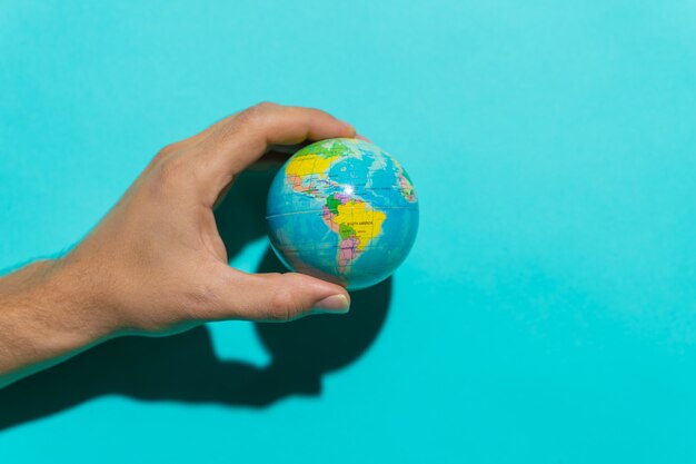 Globe ball in top of a red book in a stool with colorful blue background with copy space for text