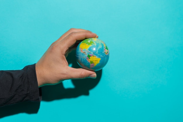 Photo globe ball in top of a red book in a stool with colorful blue background with copy space for text