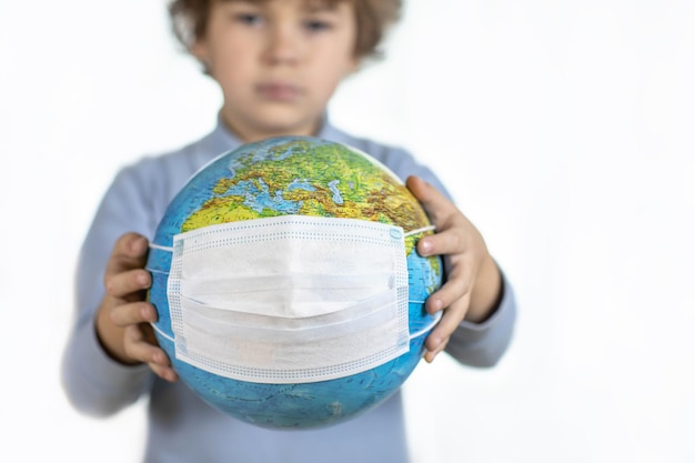 지구상의 바이러스 개념 어린이의 손에 있는 코비드 마스크의 지구