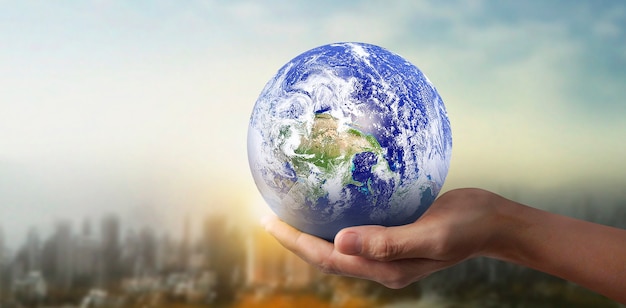 Глобус, земля в человеческой руке, держит нашу светящуюся планету.