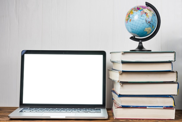 Globe en boeken in de buurt van de laptop