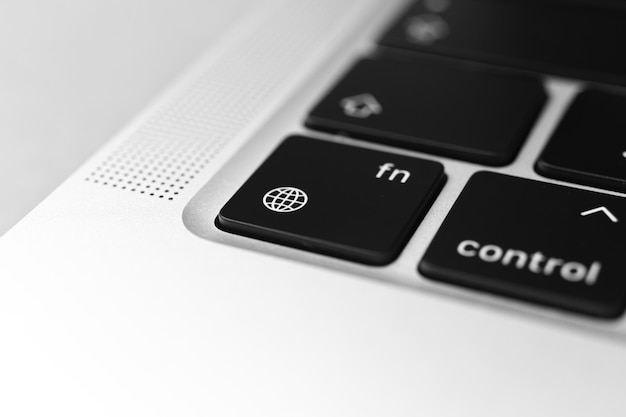 The globe key and button on keyboard. The globe and language settings sign close-up. Modern laptop, communication concept photo