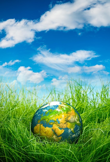 Photo globe lies on green grass. concept - earth day.