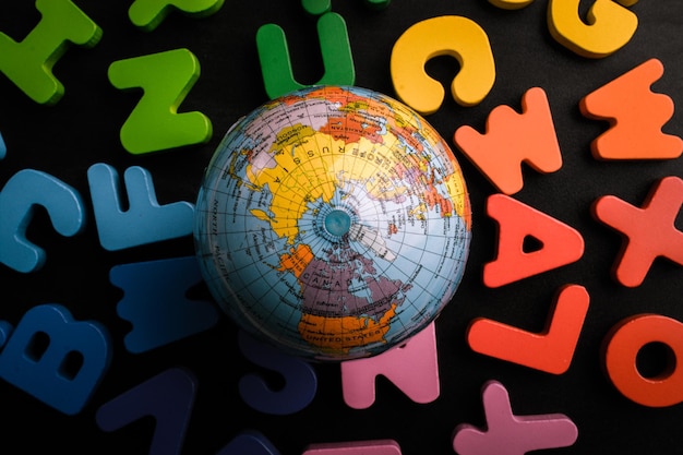 Photo globe model on colorful letters on a black background