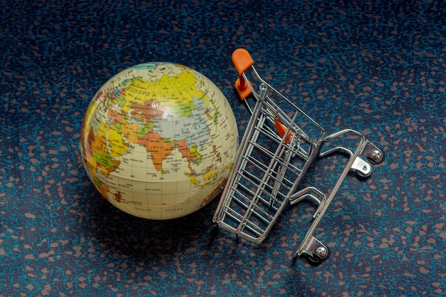 Globe and Shopping cart or shopping trolley seen as business concept