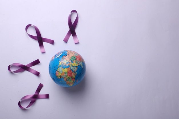 A globe surrounded by purple ribbons to commemorate a World Cancers Day