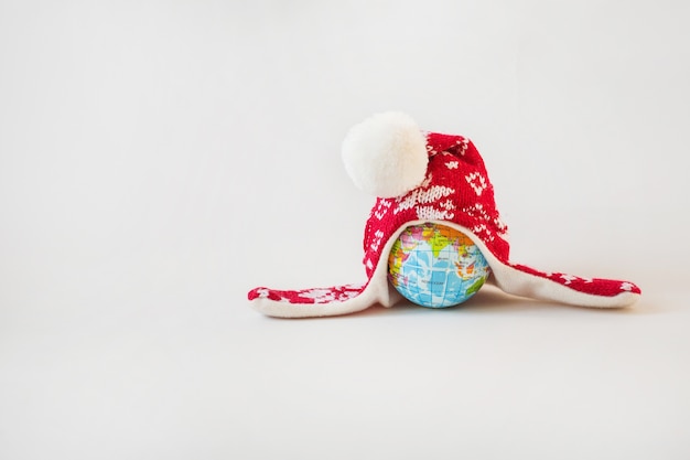 Globe in winter hat. Christmas minimalism concept