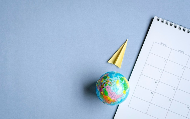 Globe with paper plane and calendar Travel concept