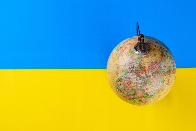 Globe on yellow and blue color Ukrainian flag No war