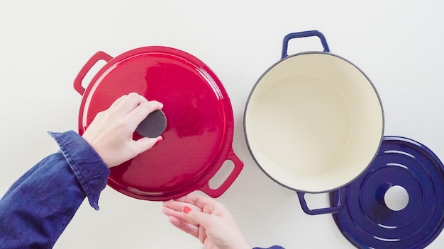 Gloednieuwe geëmailleerde gietijzeren overdekte Nederlandse oven op een witte achtergrond.