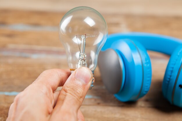 Foto gloeilamp en koptelefoon op een houten tafel