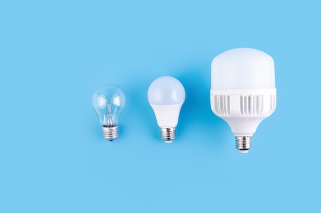 Gloeilamp en led-lampen tegen op blauwe achtergrond Energie-efficiëntieconcept Plat leggen