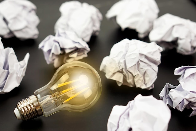 Gloeilampen gloeien oranje en verfrommeld papier Goed idee creativiteit en inspiratie concept
