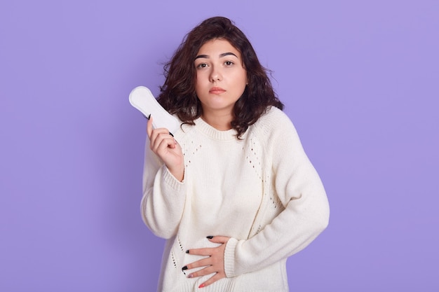 Gloomy woman with dark wavy hair cares about personal hygiene