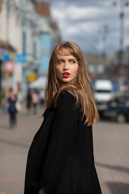 Glorieuze brunette dame draagt een pak dat door de stad loopt