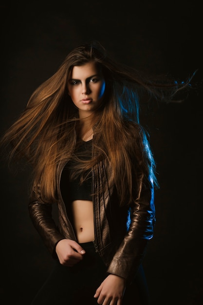 Glorious brunette woman with long hair in motion at studio