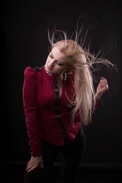 Photo glorious young woman with fluttering  hair posing at studio