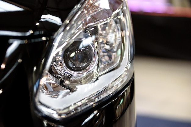 Glossy headlamp in a modern car in closeup very low DOF