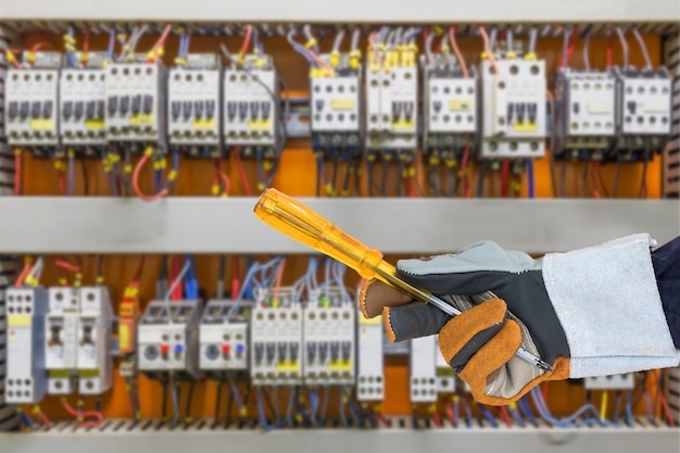 Glove holding screwdriver in control panel cabinet