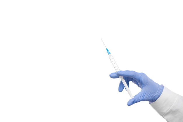 Gloved hand of doctor or nurse holding syringe with liquid vaccine before injecting over white background with copyspace on the left