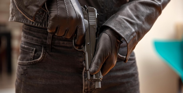 Gloved hand holding a pistol closeup view