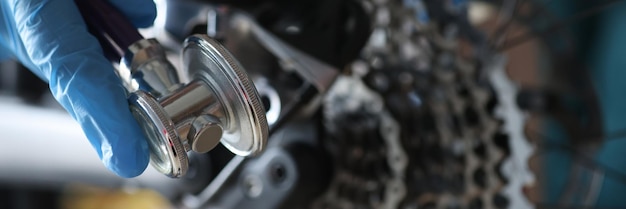 A gloved hand holds a key to adjust the bike