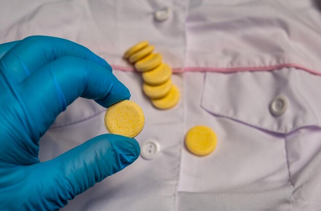 Photo a gloved hand holds vitamins in tablets