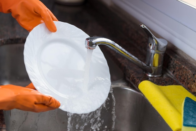 gloved hand, washing dishes