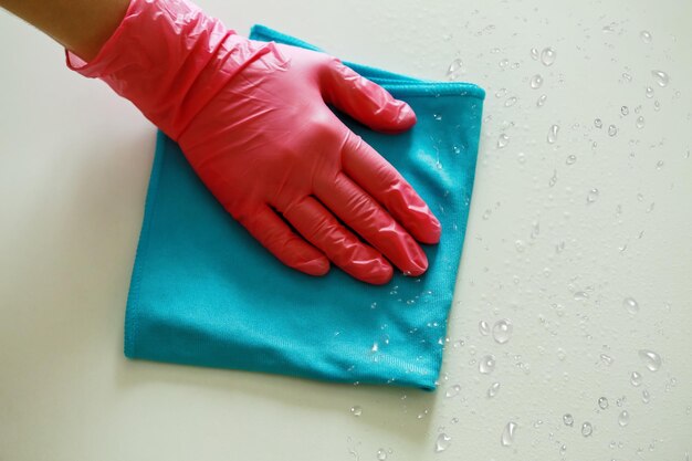 Photo gloved hand wipes the dustwetcleaning of the house