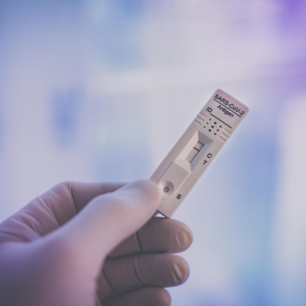 Photo gloved hand with sars-cov-2 rapid antigen test nasal self test verifies positivity covid-19